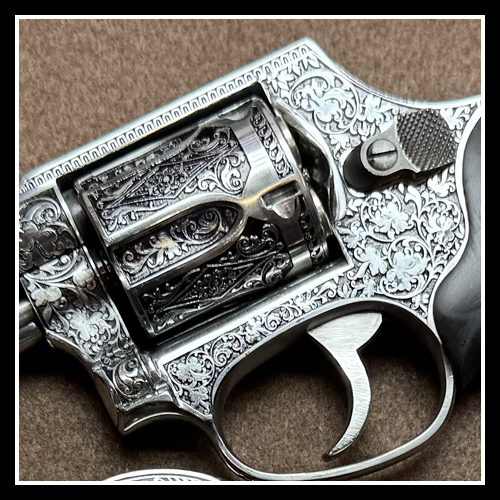 A photograph of a deep engraved revolver with scrolls.