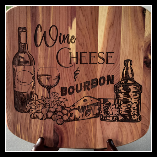 A photograph of a wooden cutting board with the text Wine Cheese & Bourbon with images depicting a bottle of wine, wine glass, whiskey bottle and glass with cheese and grapes.